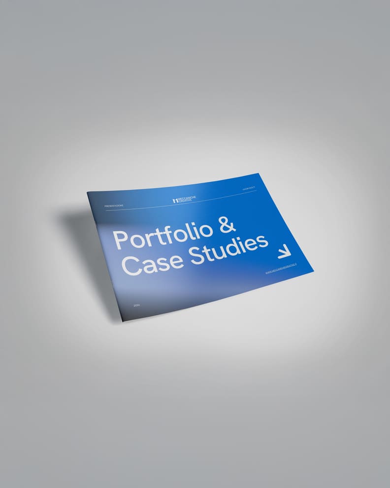Brochure aziendale di Meccaniche Creative con copertina blu e testo bianco in grassetto che recita 'Portfolio & Case Studies'. Il design è moderno e minimalista, con il logo dell'azienda nella parte superiore e un'icona a forma di freccia in basso a destra. La brochure è posata su una superficie chiara con un'ombra soffusa